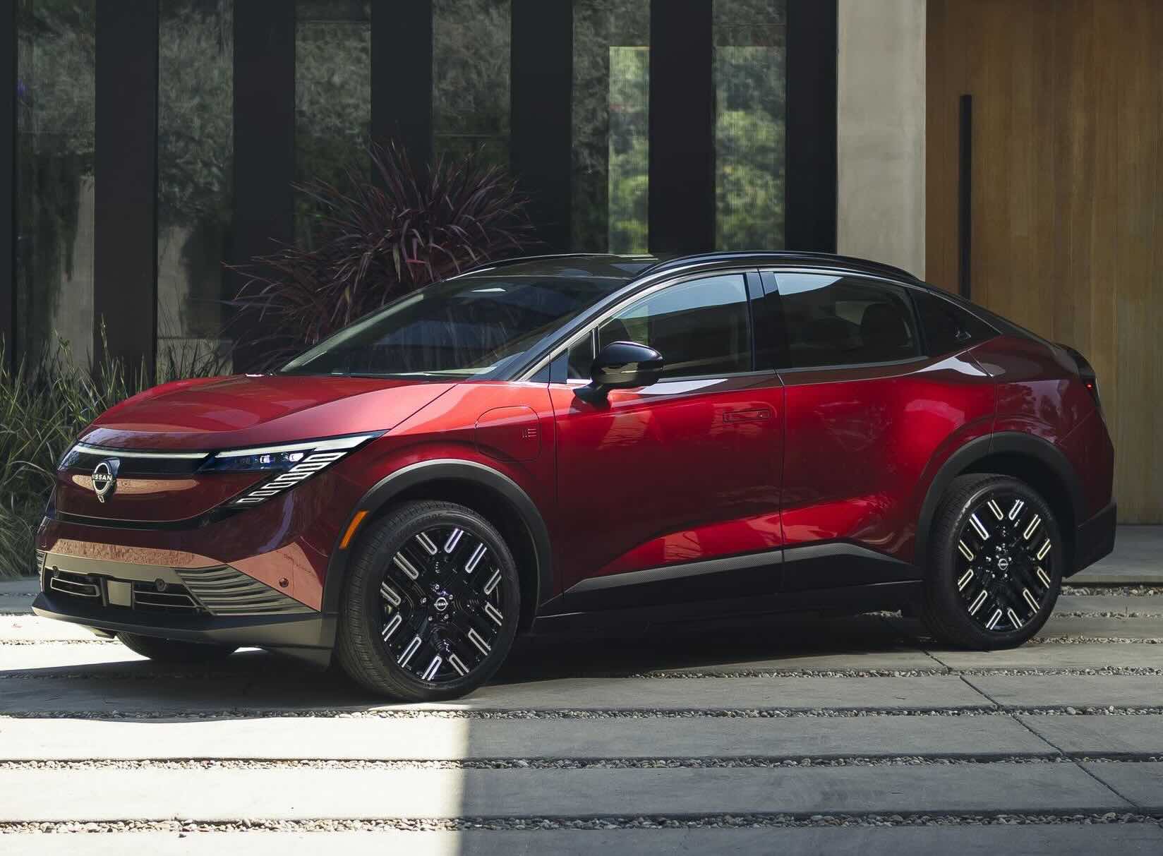 A photo of a red 2026 Nissan LEAF parked in front of a building at Nissan of Bowie.