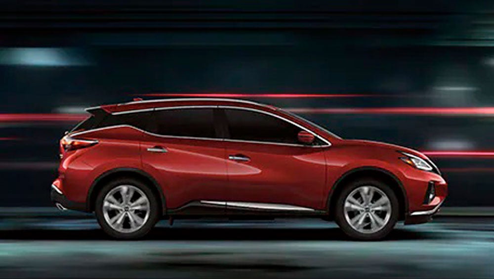 2023 Nissan Murano shown in profile driving down a street at night illustrating performance. | Nissan of Bowie in Bowie MD