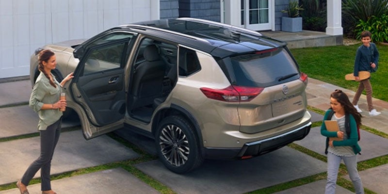 Familia junto a una Nissan Rogue 2025 con la puerta trasera abierta